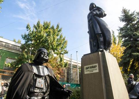 TO GO WITH AFP STORY BY OLGA SHYLENKO A participant dressed as Darth Vader, a character from the 'Star Wars' film, takes part in an inauguration ceremony of a Darth Vader monument, formerly a statue of Soviet founder Lenin, in the southern Ukrainian city of Odessa on October 23, 2015. Just in time for the release of the latest "Star Wars" blockbuster, Ukrainians have transformed the statue of Lenin into one of Darth Vader, an oddly prominent figure in local politics. AFP PHOTO / VOLODYMYR SHUVAYEV